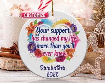 May include: A white ceramic ornament with a floral heart design and the text "Your support has changed my life more than you'll ever know." Includes the name "Samantha" and the year "2026".