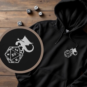 May include: Black hoodie with a white embroidered design of a dragon holding a twenty-sided die.