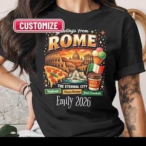 May include: Black t-shirt with a vibrant graphic of Rome, including the Colosseum, Vatican, and Trevi Fountain. The design also features pizza, ice cream, and the text "Greetings from Rome." Includes the name "Emily" and the year "2026".