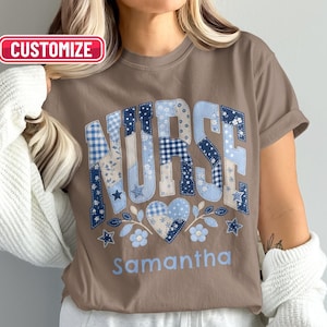Puede incluir: Una camiseta marrón de manga corta con la palabra NURSE en un patrón de patchwork azul y blanco con estampados de flores, cuadros y estrellas. Debajo del texto hay un corazón azul, detalles florales y el nombre Samantha en azul claro.