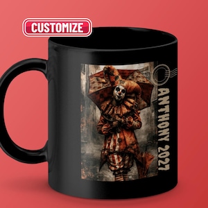 Puede incluir: Una taza de cerámica negra con un gráfico de un payaso sosteniendo un paraguas, con el texto "ANTHONY 2027" impreso verticalmente en el lateral. Un botón rectangular "CUSTOMIZE" es visible en la esquina superior izquierda de la imagen.