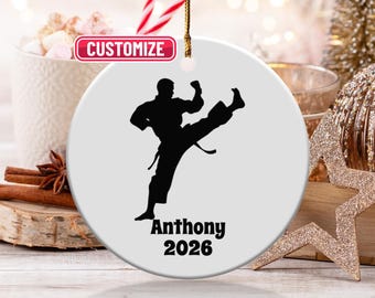 May include: A white ceramic ornament featuring a black silhouette of a martial artist in a kicking pose. The name "Anthony" and the year "2026" are printed in black. The word "Customize" is in a red banner.
