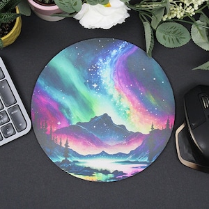 Pu&ograve; includere: Tappetino per mouse rotondo con una scena colorata di aurora boreale sopra una catena montuosa e un lago. L'aurora &egrave; in tonalit&agrave; di rosa, viola, verde e blu. La catena montuosa &egrave; blu scuro e il lago &egrave; blu chiaro. Lo sfondo &egrave; un cielo blu scuro con stelle.