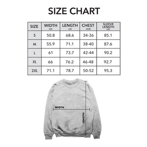 Puede incluir: Una tabla de tallas para una sudadera, con medidas en cent&iacute;metros y pulgadas. La tabla incluye las tallas S, M, L, XL y 2XL, con las medidas correspondientes de ancho, largo, pecho y largo de manga. Se muestra una sudadera gris en la parte inferior.