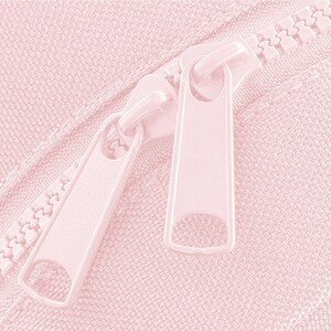 Puede incluir: Primer plano de una cremallera rosa con dos deslizadores. La cremallera est&aacute; cerrada y los deslizadores est&aacute;n en la posici&oacute;n superior.