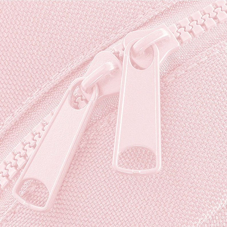 Puede incluir: Primer plano de una cremallera rosa con dos deslizadores. La cremallera est&aacute; cerrada y los deslizadores est&aacute;n en la posici&oacute;n superior.