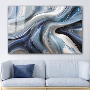 以下が含まれることがあります： 青、白、黒の渦巻き模様の抽象的な壁画。アートワークは、薄い青色のソファと青いクッションの上に置かれた白い壁に飾られています。