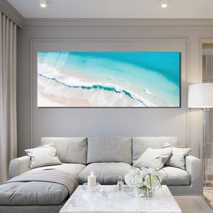 May include: A panoramic photograph of a beach with turquoise water and white sand. The photo is taken from above, showing the waves crashing on the shore.