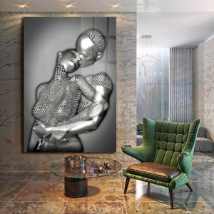May include: A black and white photograph of a couple embracing. The couple is depicted in a silver, metallic, textured style. The image is printed on a canvas and framed.