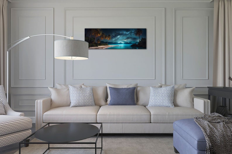 May include: A living room interior design featuring a white sofa with three cushions, a black coffee table, a blue footstool with a throw blanket, and a floor lamp with a grey shade. A panoramic photograph of a tropical beach scene with palm trees and a starry night sky hangs on the wall.