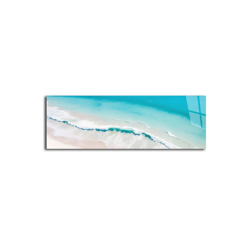 May include: An aerial view of a turquoise ocean with white waves crashing on a sandy beach.