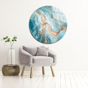 May include: A round wall art piece with a blue and gold abstract design. The design features swirling patterns and gold glitter accents.