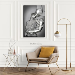 May include: A black and white photograph of a couple embracing. The couple is depicted as a silver, metallic sculpture. The image is printed on a glass panel with the text "GlassState Luxury" printed below the image.
