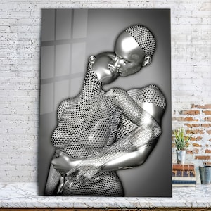 May include: A silver-toned sculpture of two figures embracing. The figures are made of a textured, honeycomb-like material. The sculpture is set against a gray background.