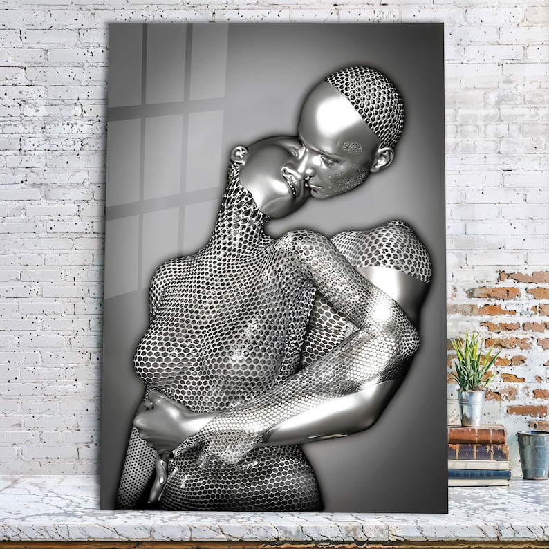 May include: A silver-toned sculpture of two figures embracing. The figures are made of a textured, honeycomb-like material. The sculpture is set against a gray background.
