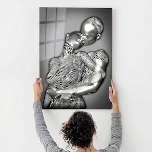 May include: A black and white abstract art print of two figures in a romantic embrace. The figures are made of a metallic material with a textured surface.