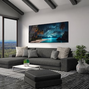 May include: A modern living room featuring a grey sectional sofa, a coffee table, and a large canvas print depicting a tropical beach scene with palm trees and a starry sky. The print is hung on a white wall.