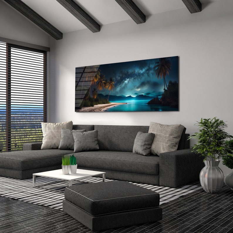 May include: A modern living room featuring a grey sectional sofa, a coffee table, and a large canvas print depicting a tropical beach scene with palm trees and a starry sky. The print is hung on a white wall.