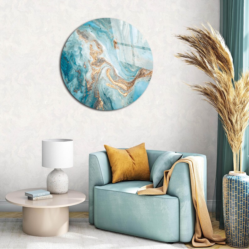 May include: A round wall decor with a blue and gold abstract design. The design features swirling patterns and hints of glitter.
