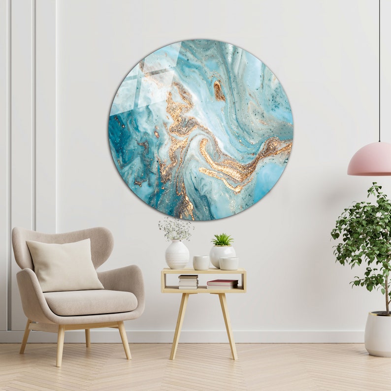 May include: A round wall art piece with a blue and gold abstract design. The design features swirling patterns and hints of glitter.