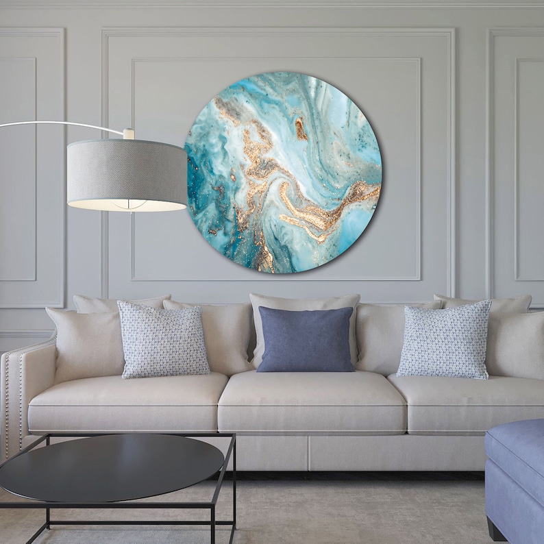 May include: A round wall art piece with a blue and gold abstract design. The design features swirling patterns and hints of glitter.