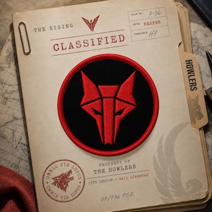 Puede incluir: Un parche bordado circular que presenta una cabeza de lobo roja estilizada sobre un fondo negro con un borde rojo. El parche está centrado en una carpeta de documentos beige etiquetada THE RISING CLASSIFIED, PROPERTY OF THE HOWLERS, 13TH LEGION, HAIL LIBERTAS.