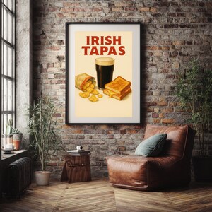May include: Framed poster with the words "IRISH TAPAS" in red. The poster features a pint of dark beer, a grilled cheese sandwich, and a bag of chips. The poster is hanging on a brick wall.