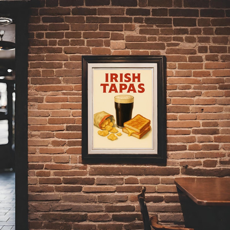 May include: A framed print with the words "IRISH TAPAS" in red. The image features a pint of dark beer, a bag of chips, and a grilled cheese sandwich. The print is displayed on a brick wall.