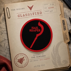 May include: A circular embroidered patch featuring a black background with a red border. The centre displays a red stylised scythe graphic above the red text "HAIL REAPER". The patch is placed on a document labelled "CLASSIFIED" with "THE HOWLERS" and "PROPERTY OF THE HOWLERS" printed in black ink.