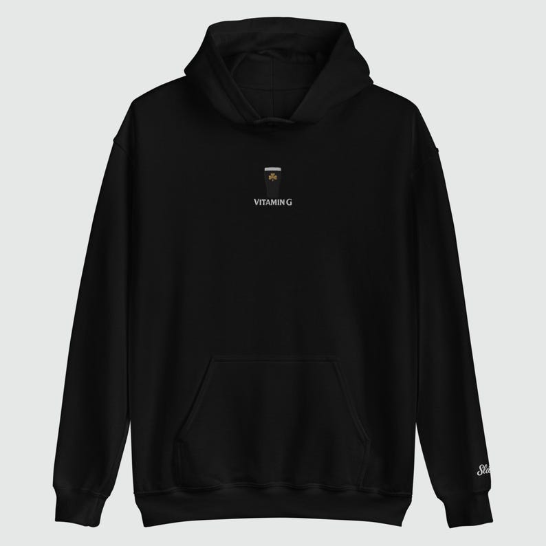May include: Black hoodie with a front pocket and a hood. The hoodie features a small graphic of a drink with the text "VITAMIN G" printed below it. The sleeve has a small embroidered logo.