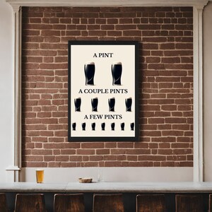 May include: A framed print featuring the text "A Pint, A Couple Pints, A Few Pints" and illustrations of stout glasses. The print is set against a brick wall, with a bar and a pint of beer in the foreground.