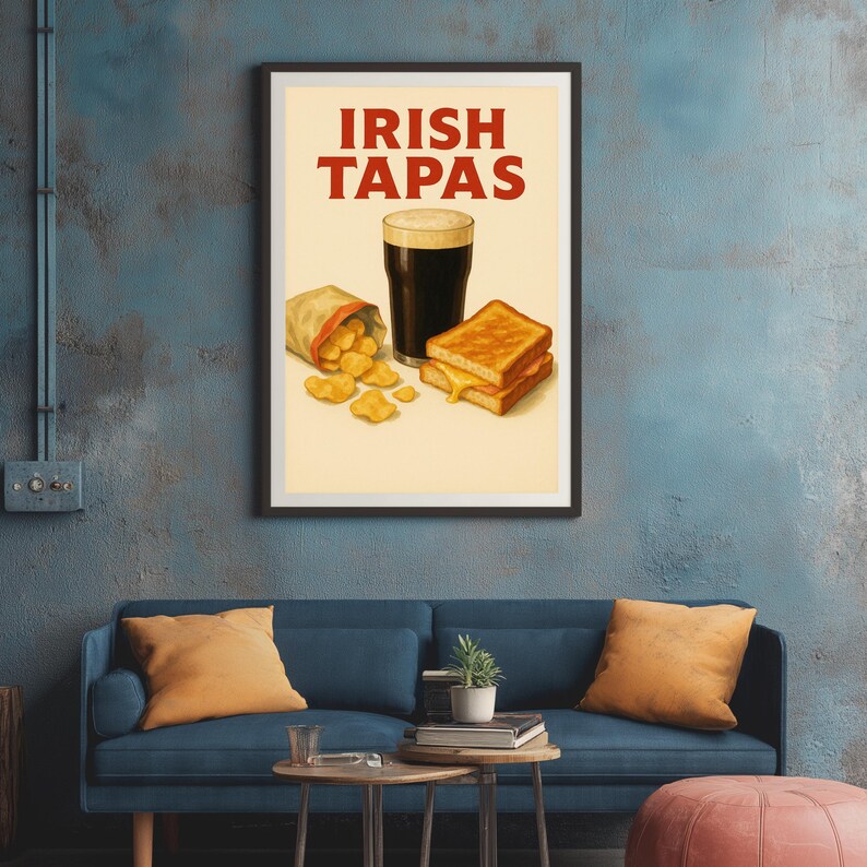 May include: A framed print featuring the words "IRISH TAPAS" in red. The image depicts a pint of dark beer, a grilled cheese sandwich, and a bag of chips. The print is displayed above a blue sofa with orange pillows.