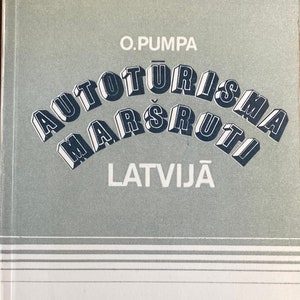 May include: A book cover with the title "Autoturisma Marsruti Latvija" in blue and white text. The cover also features a blue and white illustration of a car driving through a mountainous landscape.
