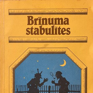 Pode incluir: Uma capa de livro amarela com o título "Brīnuma stabulītes" em texto castanho. A capa apresenta uma ilustração azul de duas figuras em silhueta contra um céu noturno com uma lua crescente e estrelas.