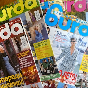 Może przedstawiać: Stosik czterech kolorowych czasopism z nadrukowanym na okładkach słowem "burda". Czasopisma dotyczą mody i zawierają artykuły o aktualnych trendach, nowych stylach oraz wskazówki dotyczące szycia i rękodzieła.