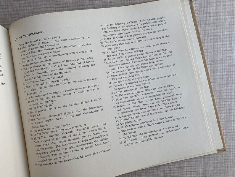 May include: A black and white photo of a book page with text about the city of Riga, Latvia. The text describes the city's history, architecture, and landmarks. The text includes the words "The skyline of Riga", "The Monument to V.I. Lenin", "The Dome Church", and "The Salaspils Memorial Ensemble".