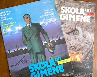 May include: Two vintage magazines titled "SKOLA un GIMENE" are displayed. The cover of the first magazine features a man in a green suit with a cityscape backdrop. The second magazine has a stone sculpture on the cover. Both magazines are from 1988.