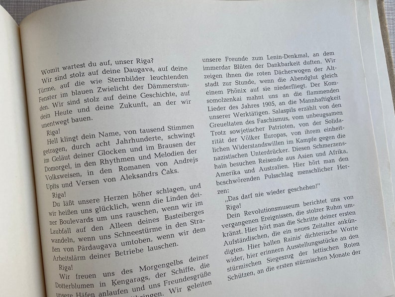 May include: A page from a book with black text on a white background. The text discusses the city of Riga, Latvia, and its history. The text includes the words "Riga!" and "The city of Riga".
