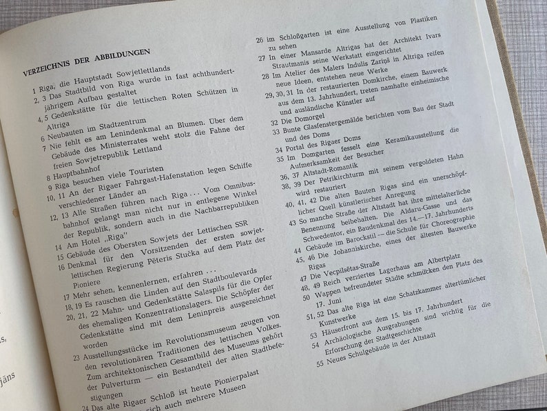 May include: A black and white page from a book with the title "VERZEICHNIS DER ABBILDUNGEN" and a numbered list of descriptions of images. The list includes the city of Riga, Latvia, and its landmarks.