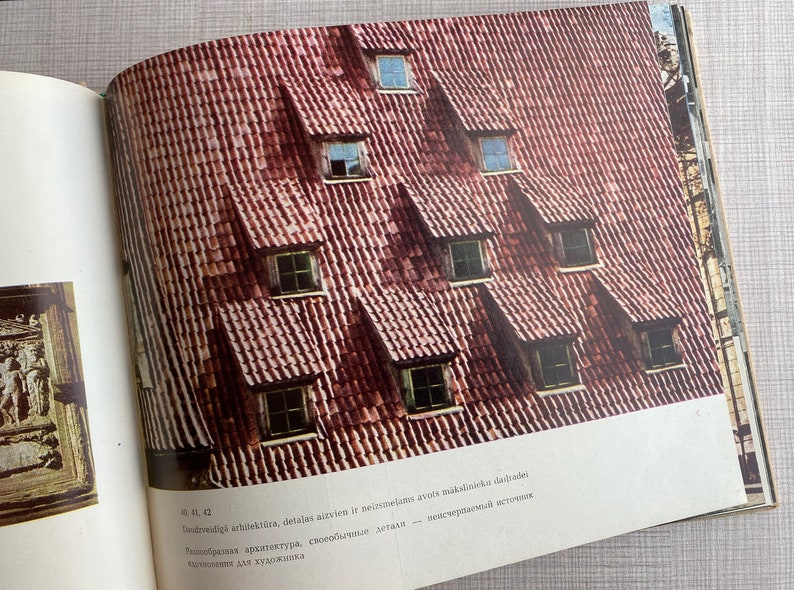 May include: A close-up of a red tiled roof with multiple dormer windows. The windows are all the same size and shape, and they are arranged in a symmetrical pattern. The roof is made of red tiles, and the windows are made of wood.