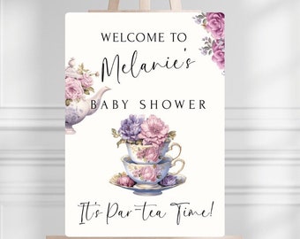 Może przedstawiać: Witamy na Baby Shower Melanie, znak z ilustracją czajnika i filiżanki do herbaty. Znak jest biały z czarnym tekstem i różowymi i fioletowymi kwiatami. Tekst brzmi "Witamy na Baby Shower Melanie To czas na herbatę!"