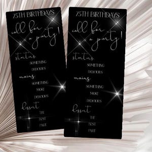 May include: Two black rectangular cards with white text and sparkling accents. The cards read "75th Birthdays, call for a party!" with sections for starters, mains, and dessert. The background is a soft, blurred neutral colour.