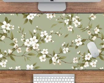 May include: A green and white floral desk mat with a white mouse on top. The mat is 78.7 cm by 39.4 cm.