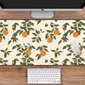 May include: A white desk mat with a repeating pattern of orange citrus fruit and green leaves. The mat measures 31 inches by 15.5 inches.