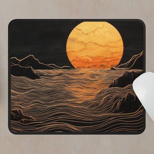 May include: A black and gold mouse pad with a stylized illustration of a large orange sun setting over a wavy ocean. The ocean is depicted with thin, white lines.