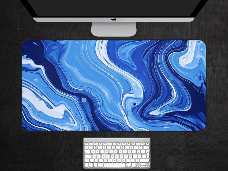 May include: Abstract blue and white marble design desk mat. The design features swirling, flowing lines of blue and white paint.
