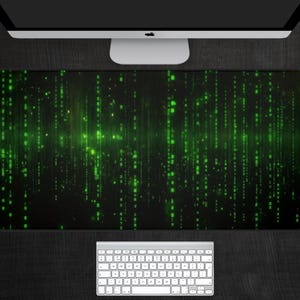 Op de afbeelding: Een zwarte en groene muismat met een digitaal regenpatroon. Het patroon bestaat uit groene codelijnen die op een zwarte achtergrond naar beneden vallen.
