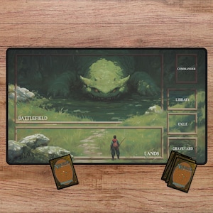 May include: A rectangular playmat with a fantasy landscape design. The mat features a green monster in a swamp, a figure with a staff, and labeled zones for a card game. Several cards are placed on the wooden surface.