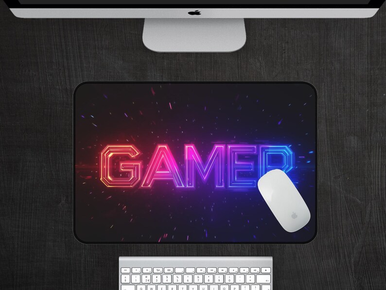 May include: A black mouse pad with a neon pink and blue "GAMER" graphic on a black background with a white mouse on the pad.