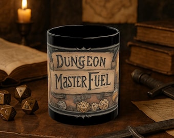 May include: Black ceramic mug with a brown and white illustration of a scroll with the text "Dungeon Master Fuel" and dice.